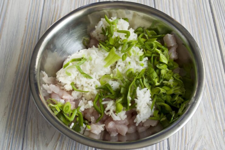 Finely chopped green garlic stalks and leaves on a cutting board.