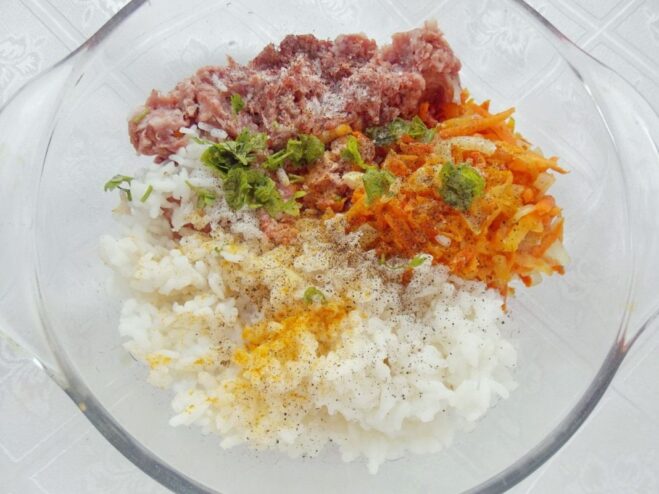 A bowl of ground meat with sautéed vegetables being added to it.