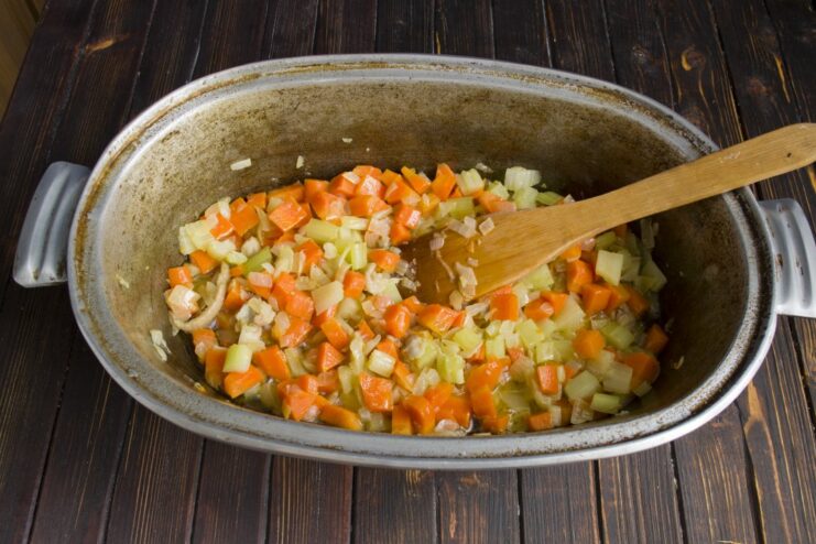 Adding carrots and celery to the rendered chicken fat for extra flavor Diced carrots and celery being sautéed with onions and rendered fat in a Dutch oven.