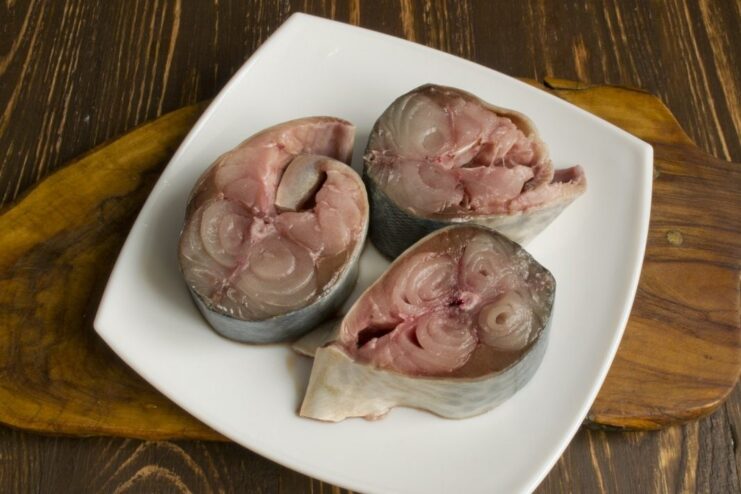 Preparing Tuna Steaks for Baking Raw tuna steaks on a cutting board ready for preparation.