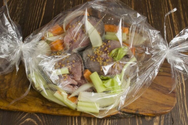 How to Use a Roasting Bag for Fish Placing seasoned tuna and vegetables inside a clear roasting bag.