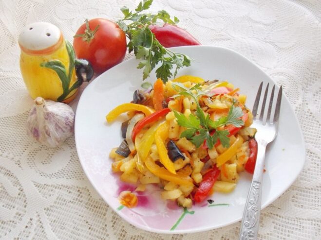 The finished dish of fried potatoes with a medley of vegetables A serving of colorful fried potatoes with vegetables in a bowl, ready to eat.