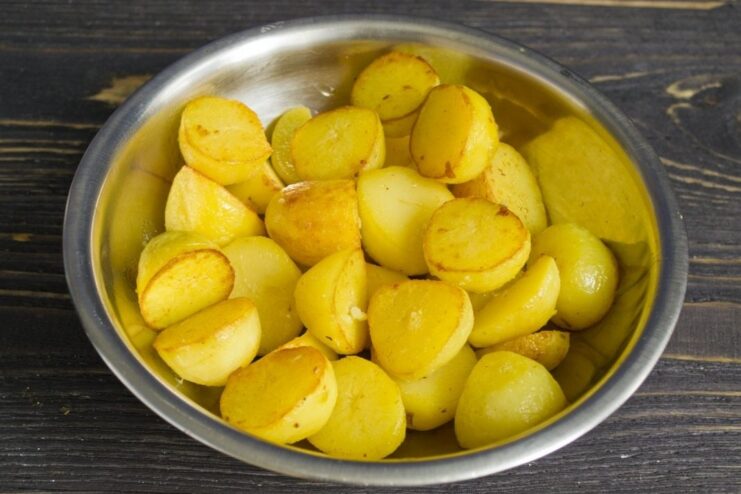 Frying Potatoes to a Golden Brown in Butter and Olive Oil Boiled new potatoes being fried in a skillet with a mix of butter and oil until golden.