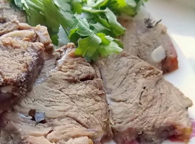 Perfectly Roasted Homemade Buzhenina, Ready to Serve Sliced homemade buzhenina served on a plate, looking juicy and delicious.