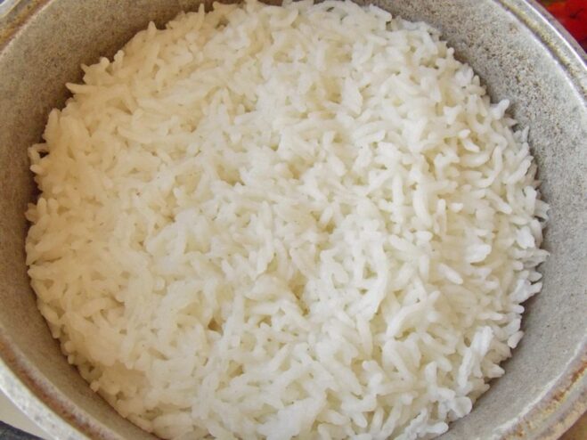 Cooking Rice for the Stuffed Pepper Filling A pot of white rice being cooked on a stove for the stuffed pepper filling.