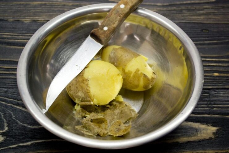 Cooking Potatoes in Their Jackets for the Perfect Gnocchi Texture Whole, unpeeled potatoes boiling in a pot of water.