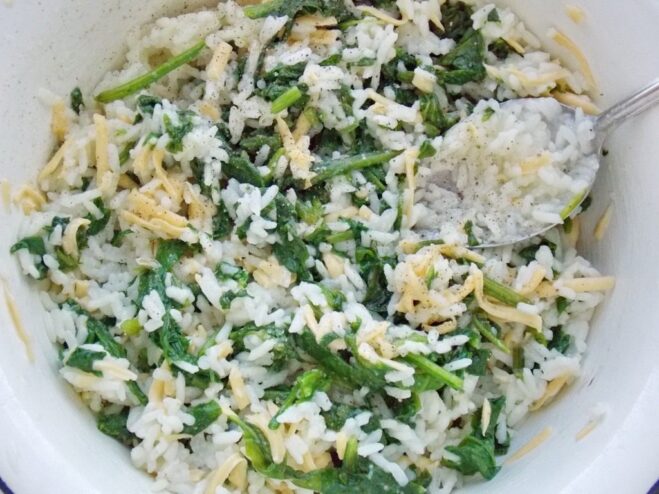 Making the vegetarian filling for golubtsy A bowl with the filling mixture: cooked rice, chopped spinach, and grated cheese.