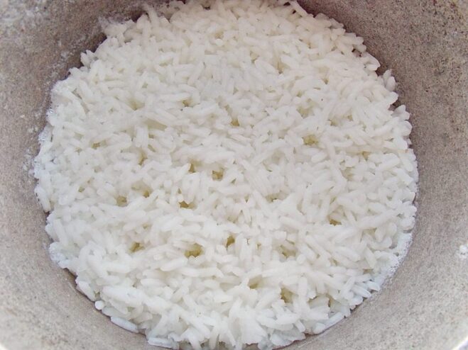 Cooking rice until almost done for the stuffing White rice cooking in a pot of water on the stove.