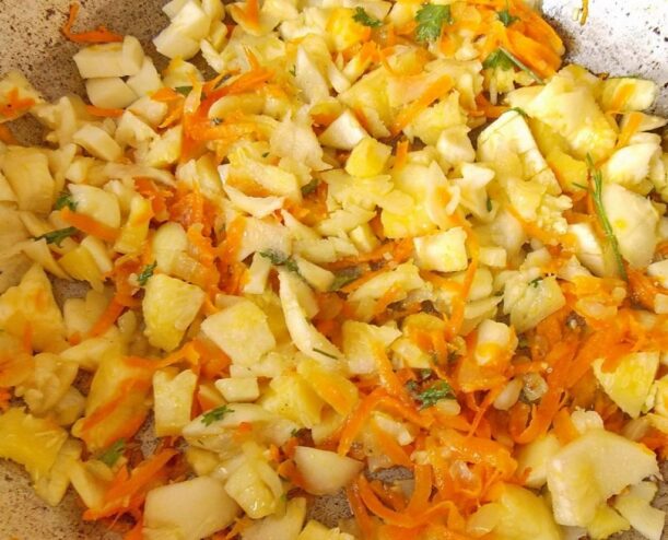 Making a simple and flavorful tomato sauce for the zucchini A pan with a simmering tomato-based sauce with vegetables.