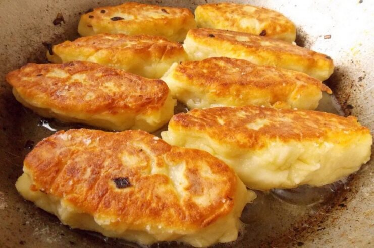 Achieving the Perfect Golden Crust on Zrazy Several potato zrazy frying in a pan, showing a crispy, golden-brown crust.