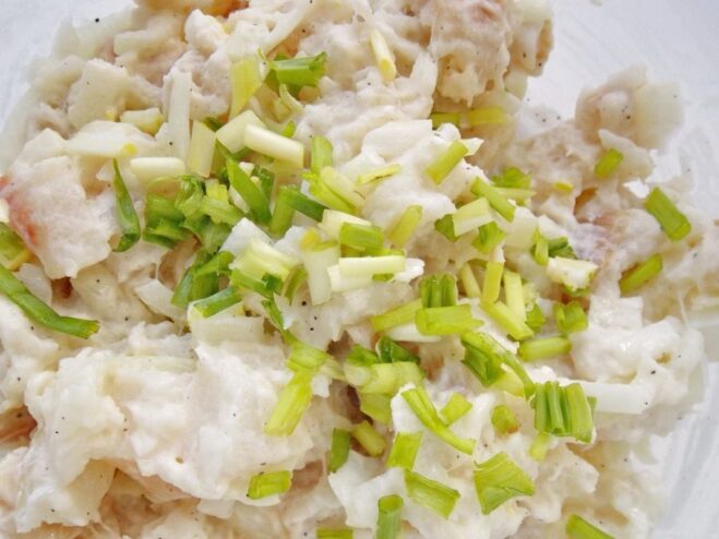 Binding the Cutlets: Adding Starch, Flour, and Herbs Cornstarch, flour, and chopped green onions added to the fish mixture in a bowl.