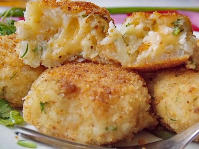 A plate of golden-brown celery and rice patties, garnished with fresh dill.