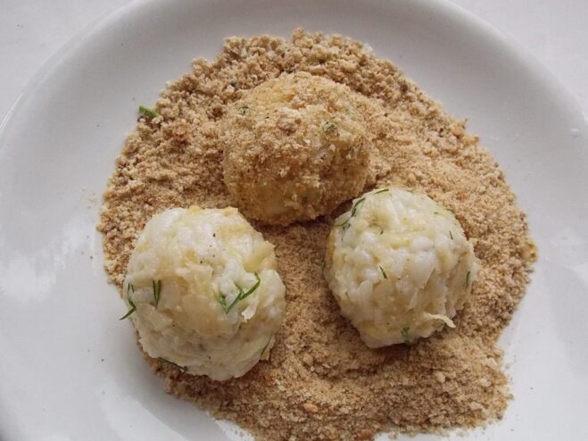 Shaping the patties and coating them in breadcrumbs Uncooked celery and rice patties coated in breadcrumbs, ready for frying.
