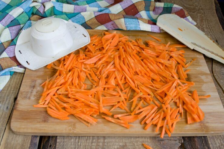 Julienned carrots ready for the Lecho A close-up of bright orange carrots cut into thin strips (julienned).