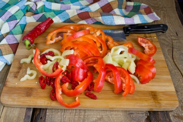 Bell peppers sliced for the vegetable stew Red bell peppers sliced into thick half-rings, ready for cooking.