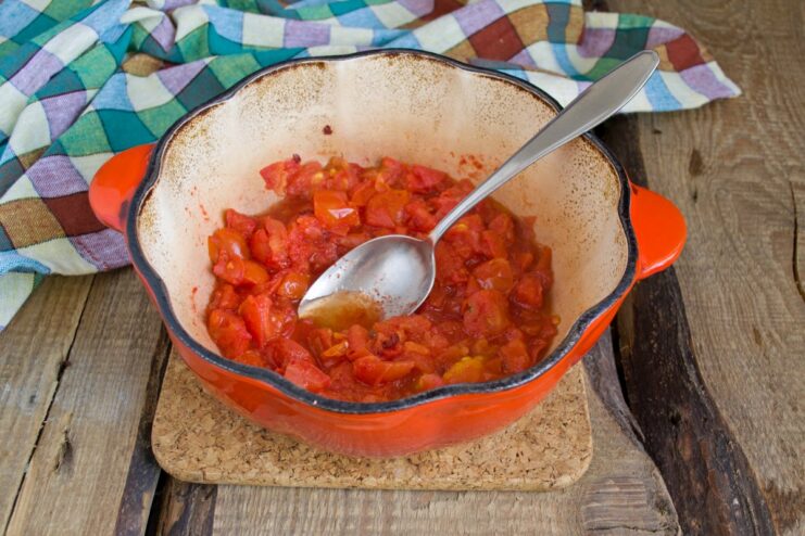 Cooking the tomato sauce for the Lecho A pot on the stove with bubbling red tomato puree.