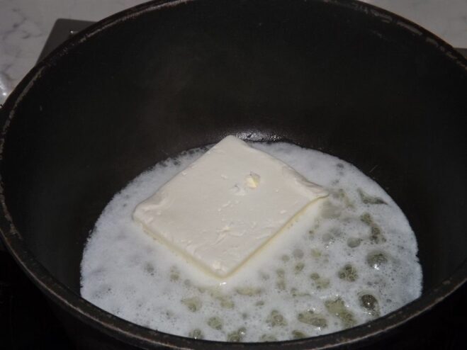 A piece of butter melting in a small saucepan.