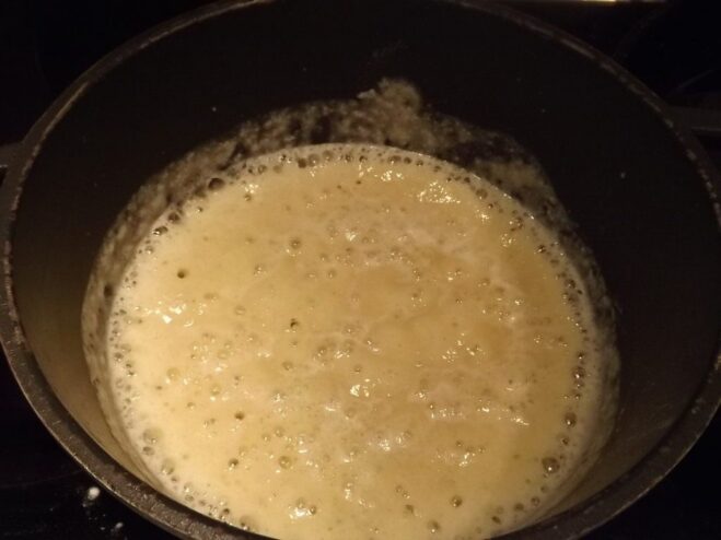 Flour being whisked into melted butter in a saucepan.