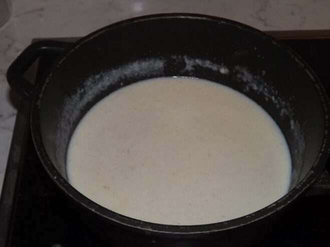 A thick, creamy white sauce in a saucepan.