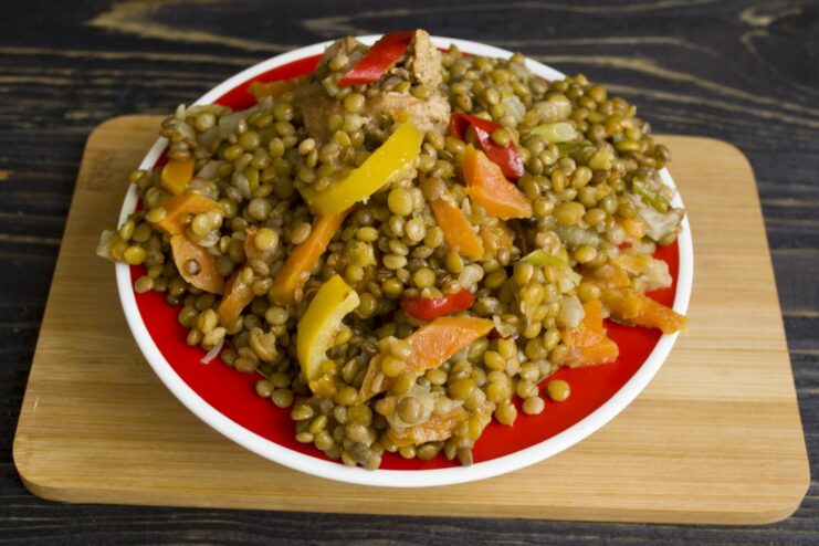 The finished lentil and chicken stew, rich in color and flavor. A serving of the finished lentil and chicken stew in a rustic bowl.