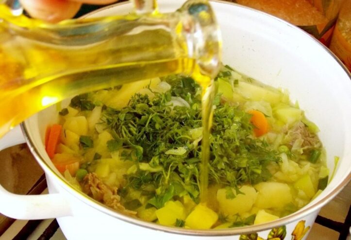 Finishing the stew with fresh herbs, oil, and salt to taste. Adding a final touch of fresh chopped herbs, a drizzle of oil, and salt to the vegetable stew.