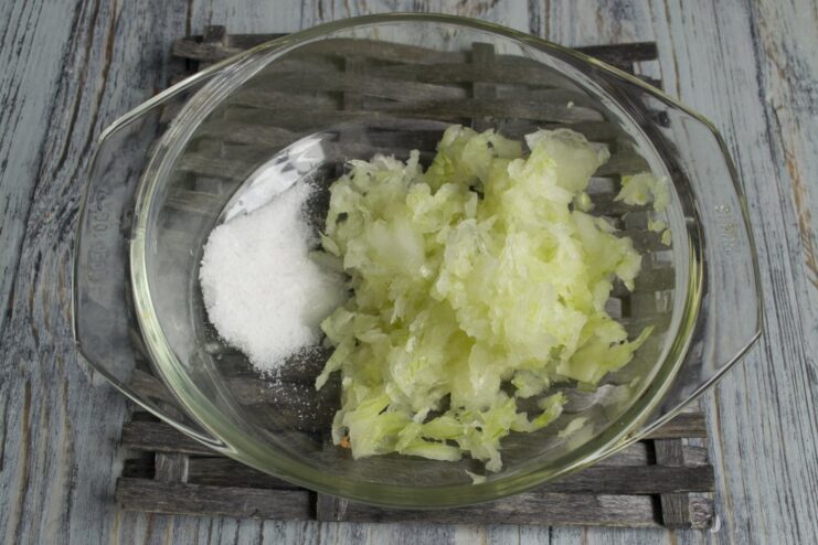 Preparing the marinade base: minced onion mixed with salt in a bowl. A bowl of minced onion being mixed with salt for the shashlik marinade.