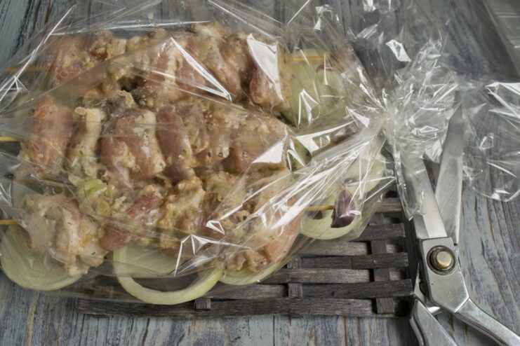 Securing the baking sleeve before putting the shashlik in the oven. The baking sleeve with pork shashlik is sealed and ready for the oven.
