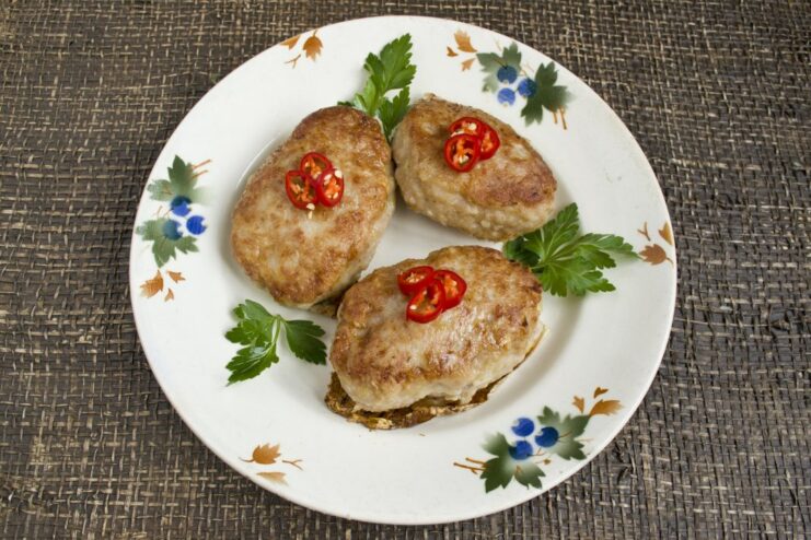 Finished juicy pork and potato patties served on a plate, ready to eat.