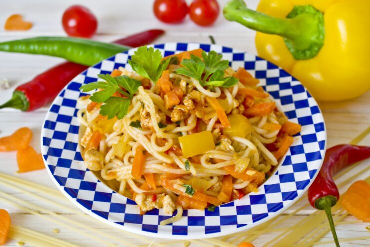 A delicious and easy-to-make plate of Spaghetti with Chicken and Vegetables. A plate of spaghetti topped with a rich chicken and vegetable sauce, garnished with fresh parsley.