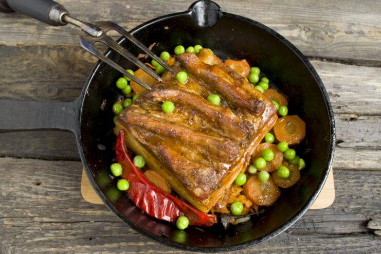 The finished oven-baked pork belly with a shiny, golden-brown crust, ready to be served.