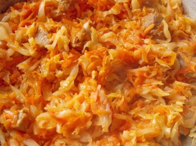 Stir in tomato paste for color and a tangy flavor boost. Tomato paste being added to the braising cabbage in the skillet.