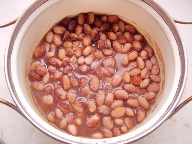 Boiling the Beans Until Perfectly Soft Soaked beans simmering in a pot of water on the stove.