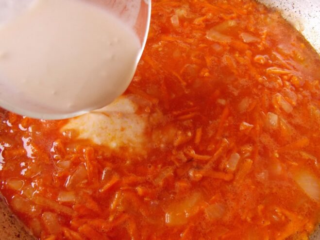 Creating a Rich Tomato Sauce Base Tomato paste and a flour slurry being stirred into the sautéed vegetables in the skillet.