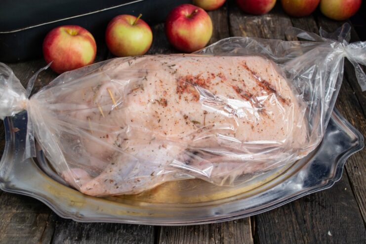 Sealing the Roasting Bag to Lock in Moisture Securing the ends of the roasting bag with the duck inside.