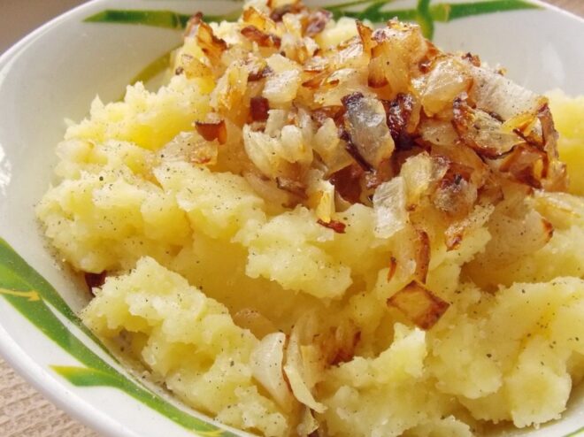 Mixing golden fried onions into the mashed potatoes for extra flavor. Adding golden fried onions to the mashed potato filling.
