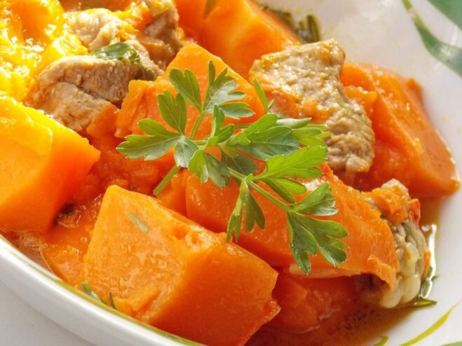 Enjoy this delicious homemade pumpkin and pork stew! A serving of the finished pumpkin and pork stew in a bowl, ready to be eaten.
