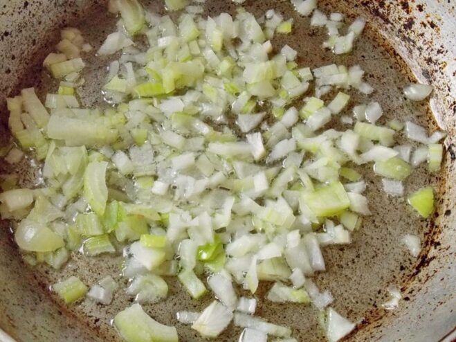 Sautéing chopped onions in a pan until translucent Chopped onions being sautéed in a hot pan with oil.
