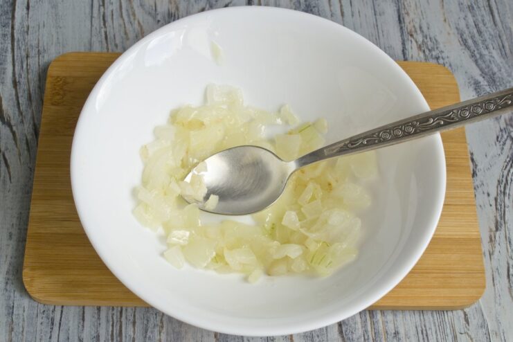 Building the Flavor Base: Sautéing Onions Finely chopped onions being sautéed in a pan until translucent.