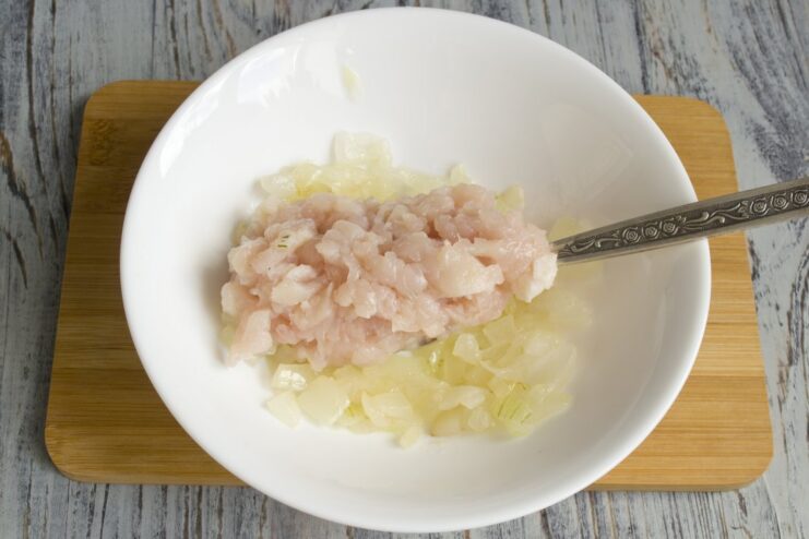 Adding Protein: Cooking the Ground Chicken Ground chicken being added to the sautéed onions in a pan.