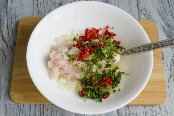 A Touch of Heat: Adding Chili Pepper Finely chopped red chili pepper being added to the filling mixture.