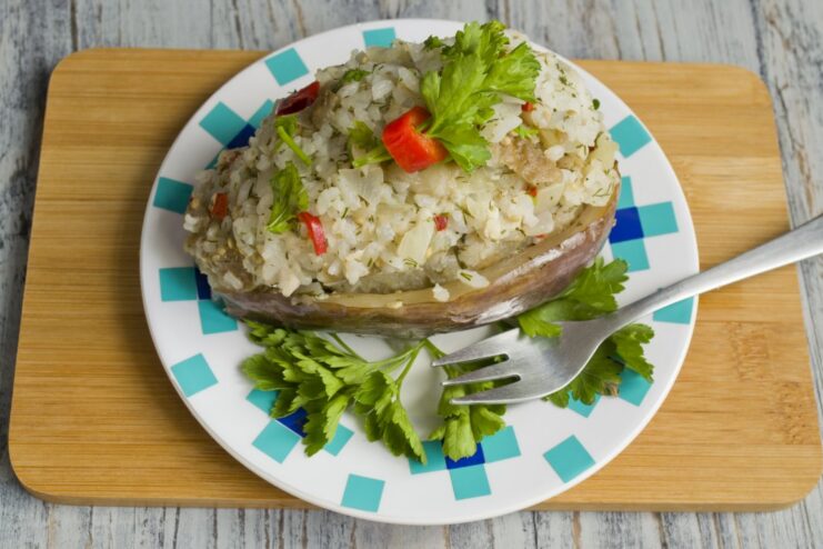 Ready to Serve: The Finished Stuffed Eggplants The finished dish of stuffed eggplants with rice and chicken, served on a plate and garnished.
