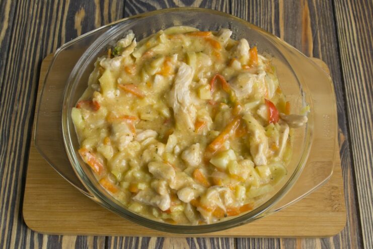Letting the Chicken Stroganoff simmer gently to meld all the flavors together. The creamy chicken and vegetable stew simmering in a black frying pan.