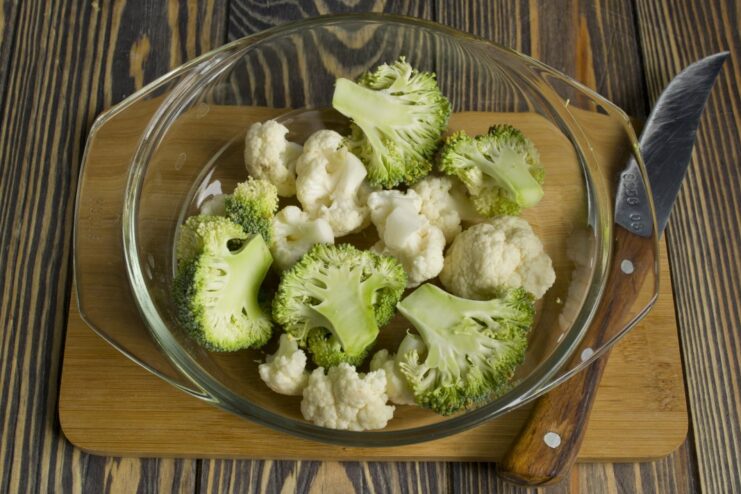 A healthy side: Steaming fresh broccoli and cauliflower to perfection. Bright green broccoli and white cauliflower florets being steamed.