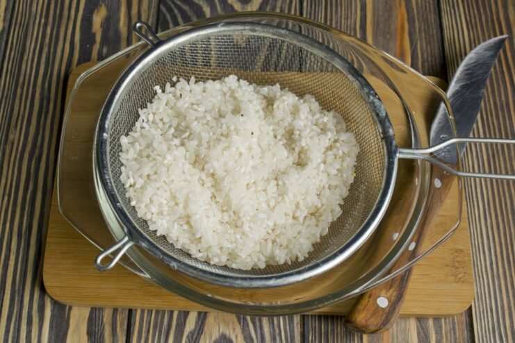 Cooking fluffy white rice to serve as the base for the Chicken Stroganoff. White rice cooking in a pot of water.