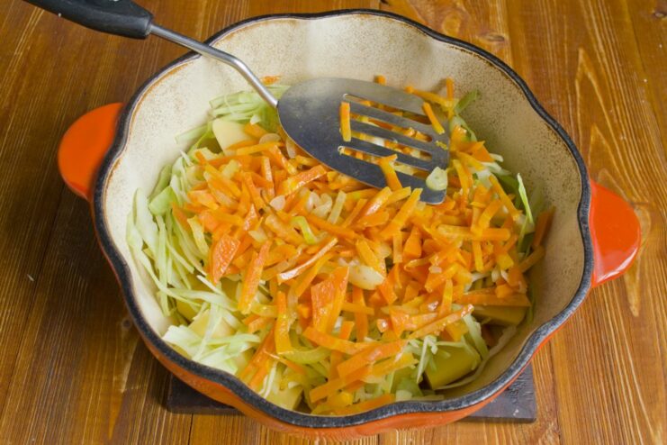 Adding the Aromatic Vegetables to the Stew Sautéed carrots, onions, and garlic being added to the pot.