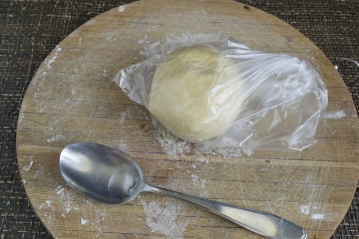 Letting the Pasta Dough Rest for Perfect Texture A smooth ball of pasta dough being placed into a plastic bag to rest.