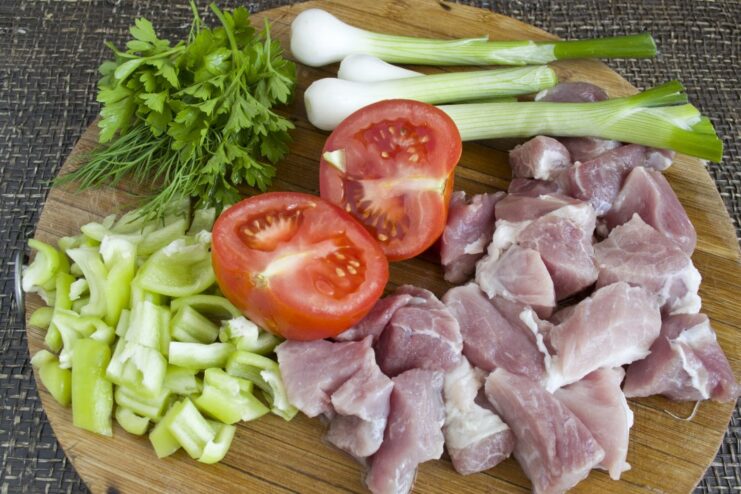Fresh Ingredients for a Rich Pork Lasagna Filling Ingredients for lasagna filling: ground pork, tomatoes, shallots, bell pepper, and fresh herbs.