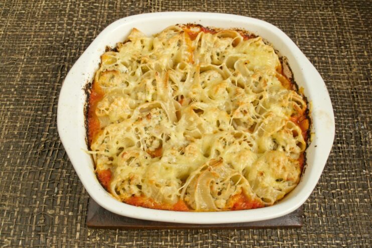 Baking the pasta until golden and bubbly The ceramic dish with stuffed pasta baking in a hot oven.