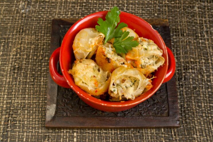 The finished dish: perfectly baked stuffed pasta The finished baked stuffed pasta in a ceramic dish, golden brown and garnished with herbs.