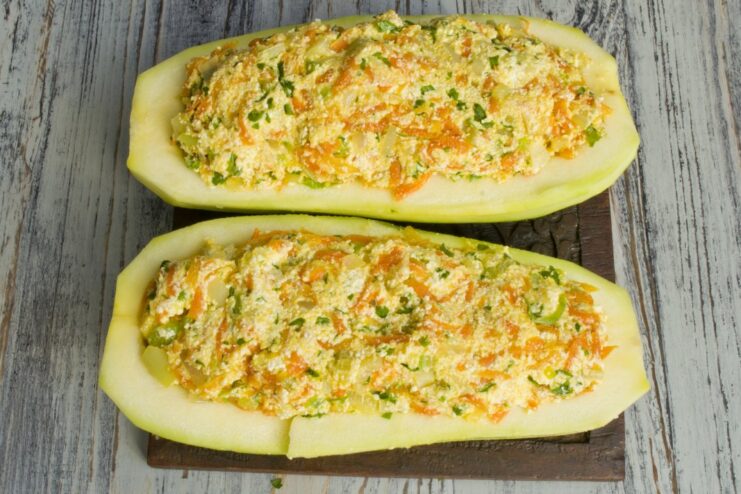 Two zucchini halves generously filled with the tvorog and vegetable mixture.